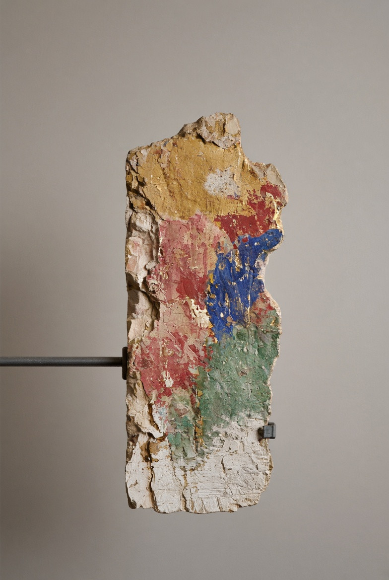 A close view of layered pigment, pale ground, and carved support
